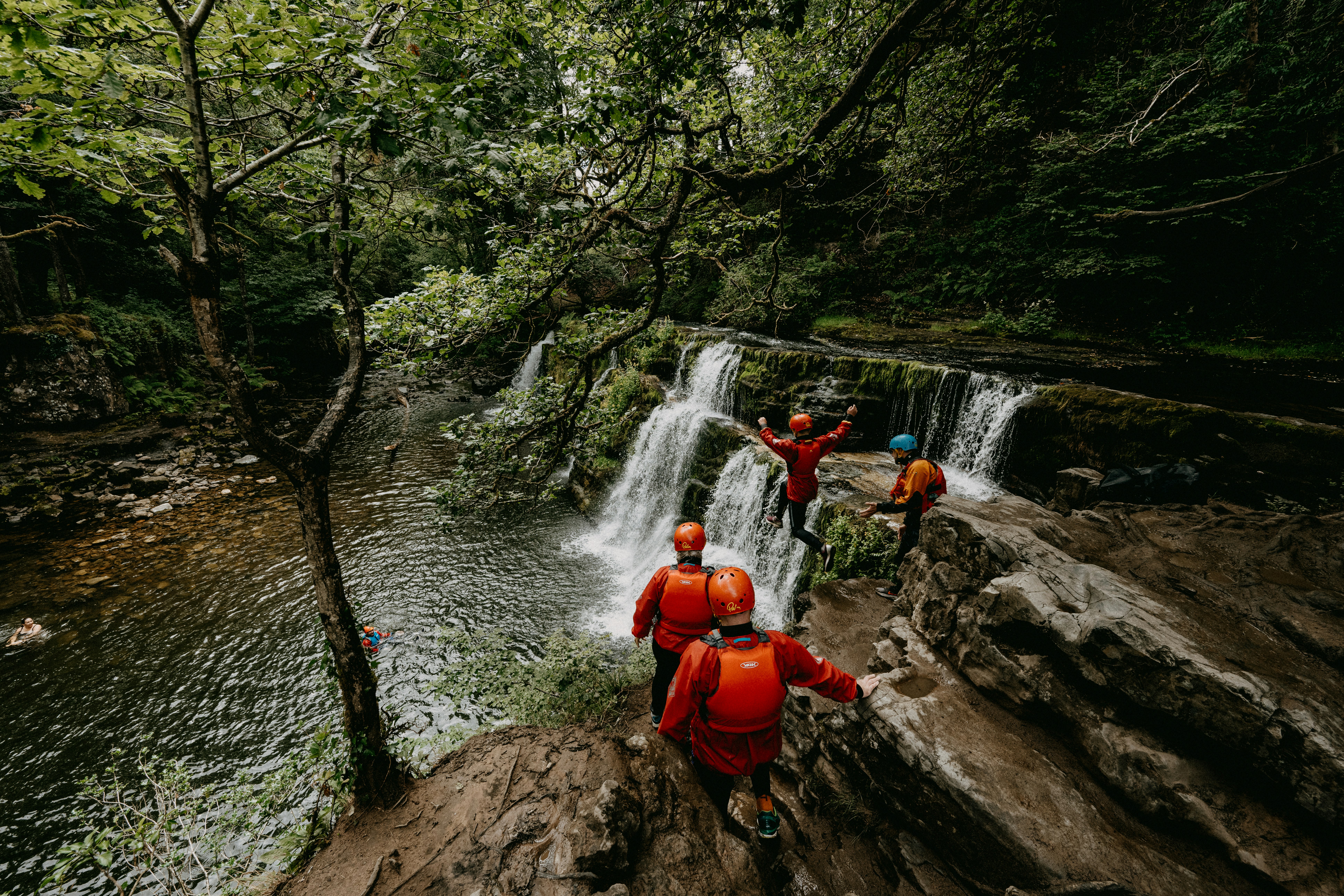 a group of people standing on top of a waterfall