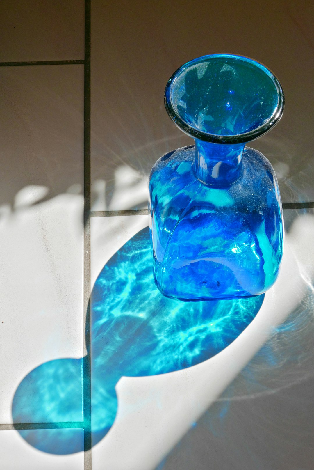 blue glass bottle on blue glass table