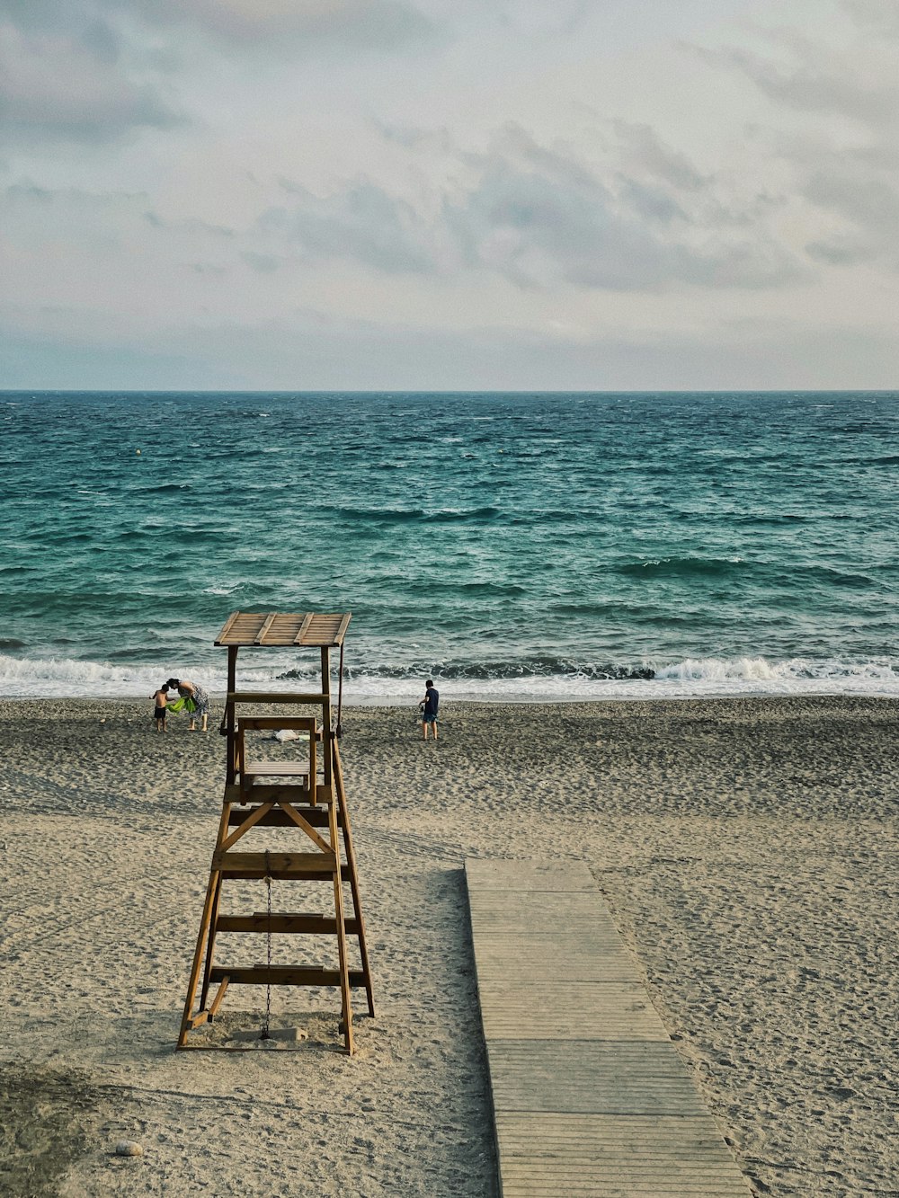 낮 동안 해변에 갈색 나무 해변 의자