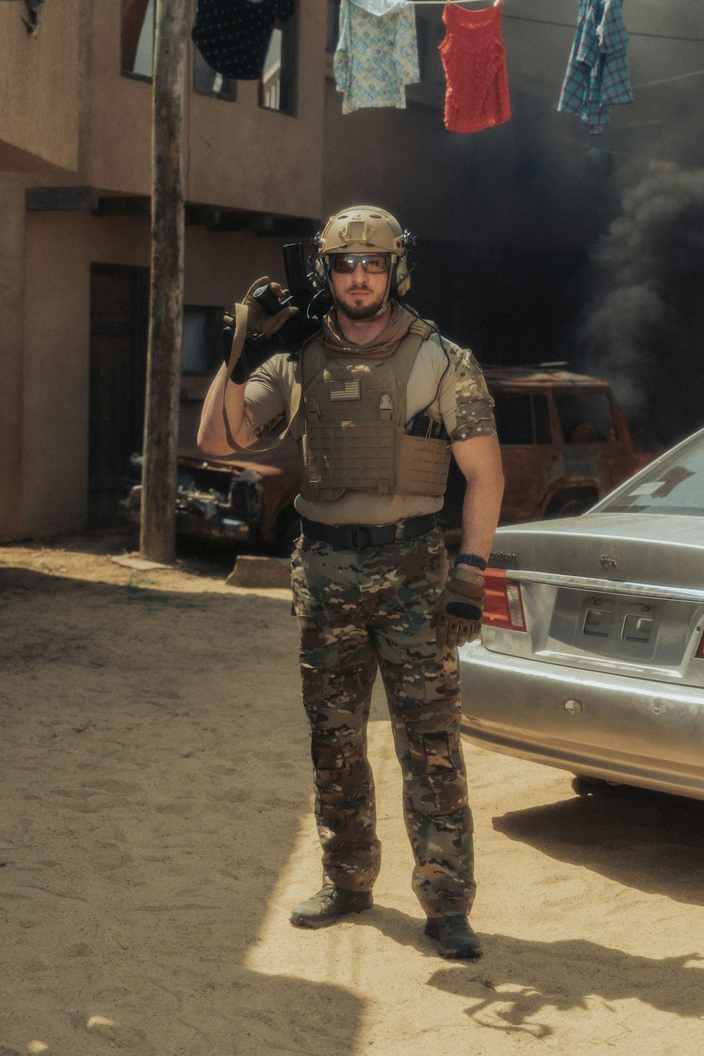 man in green and brown camouflage uniform standing beside silver car