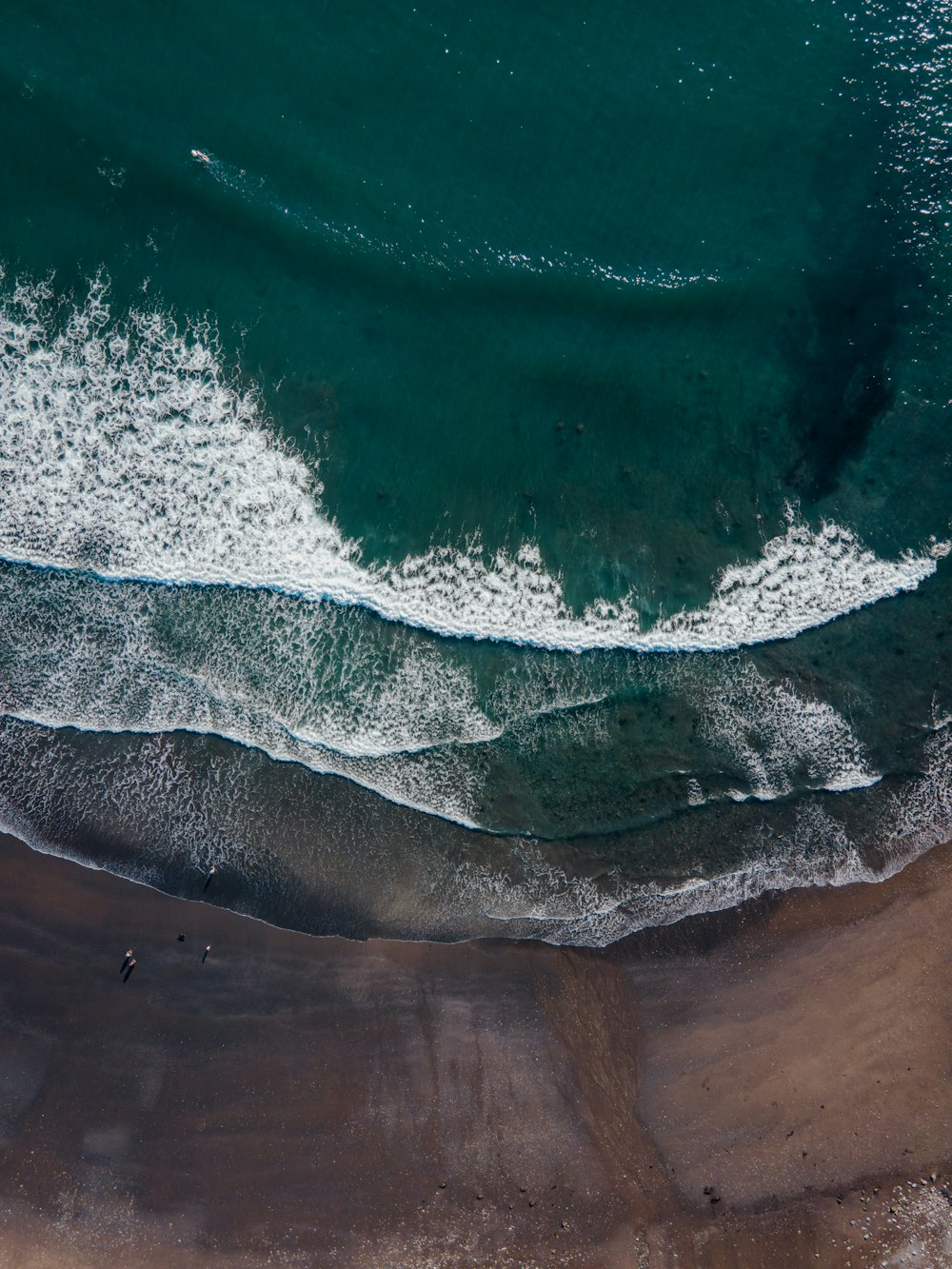 aerial view of ocean waves on shore during daytime