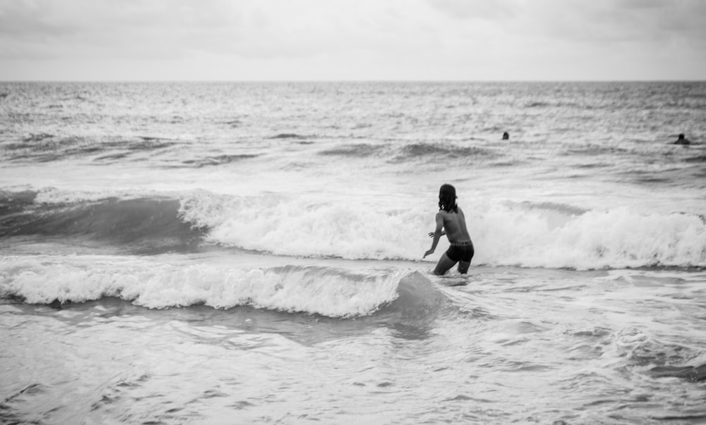 man in black wet suit surfing on sea waves