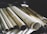 Several rolled-up sheets of paper are placed on a surface, likely containing architectural plans or blueprints. The image is focused on the cylindrical form of the scrolls, showing the textured and slightly yellowed paper. The background is dimly lit, adding a sense of age or antiquity to the scene.