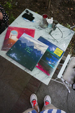 Artistic shot of vinyl records and streetwear laid out on a graffiti-covered table.