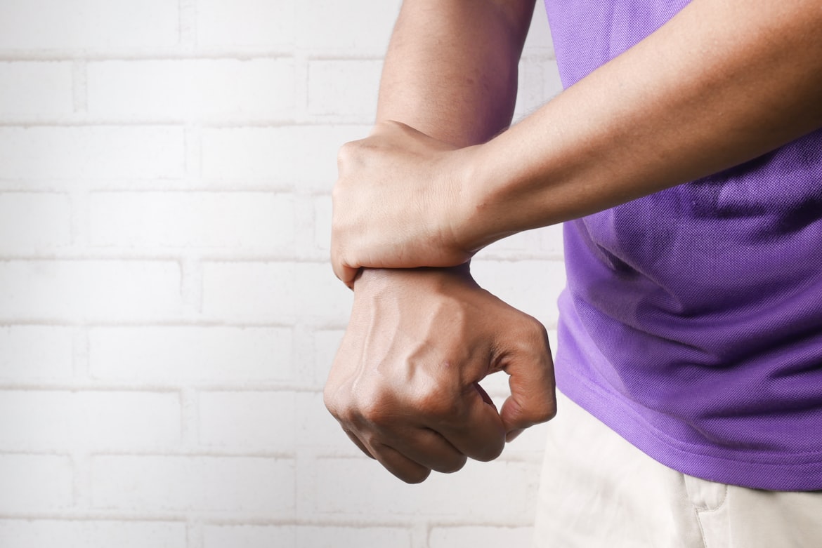 A person gripping their wrist in pain from carpal tunnel syndrome.