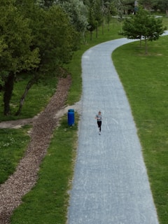 A person using a fitness app on a smartphone while jogging in a park.