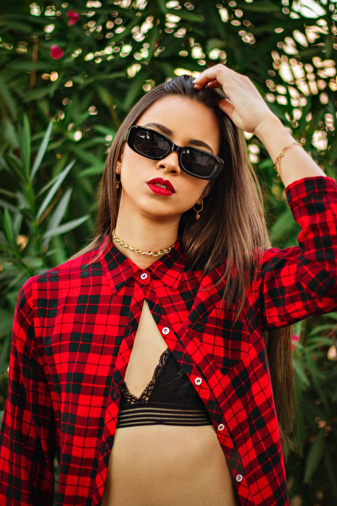 woman in red and black plaid dress shirt wearing black sunglasses