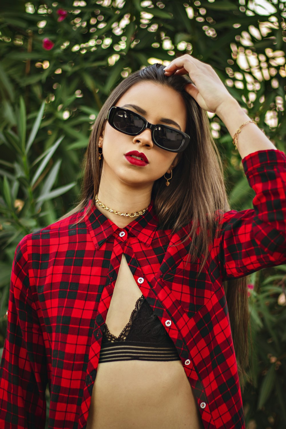 woman in red and black plaid dress shirt wearing black sunglasses