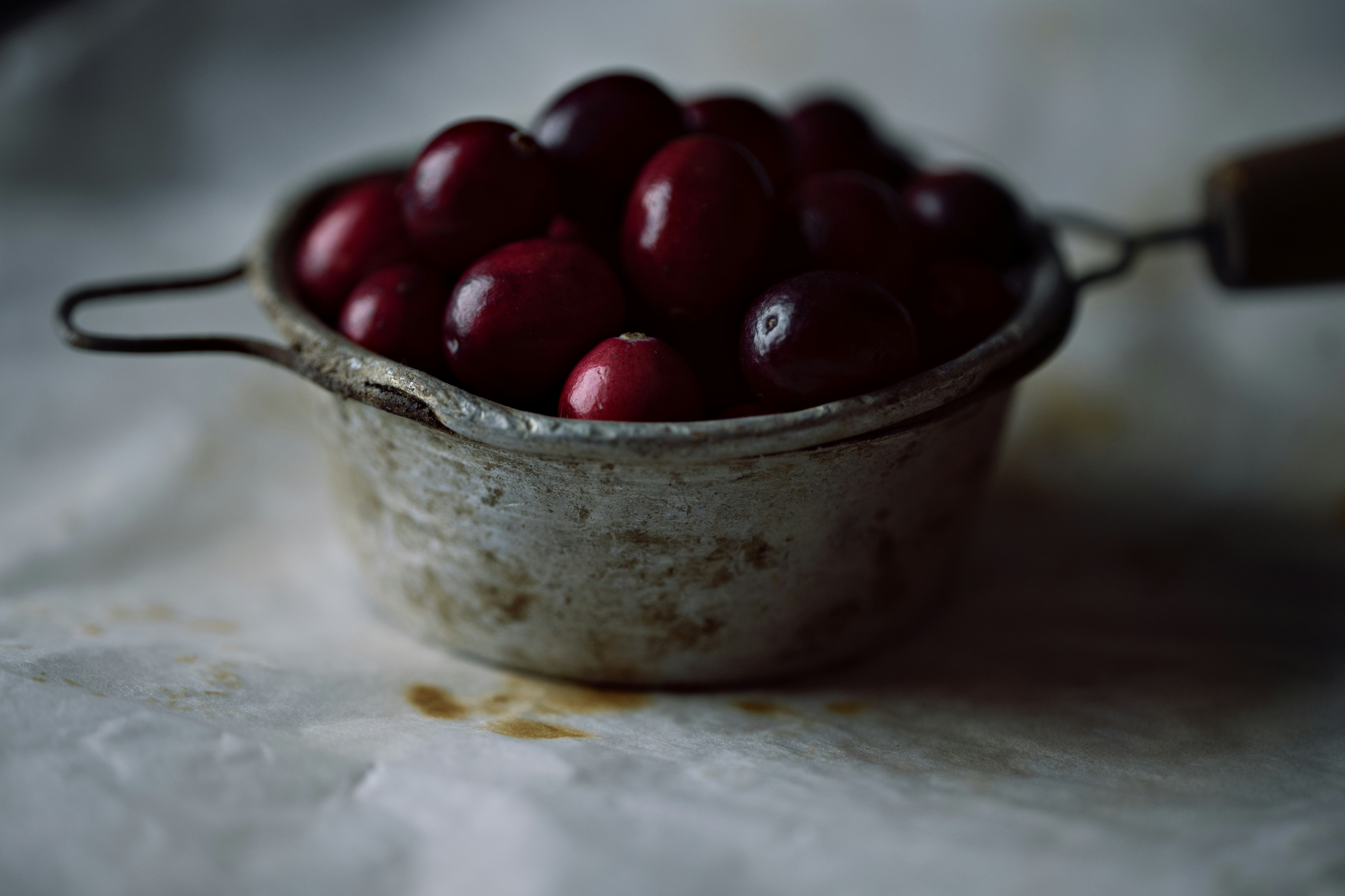 red cherries in stainless steel bowl cranberry teams background