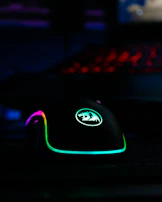 Gaming mouse with customizable buttons and glowing RGB patterns on a textured mousepad.