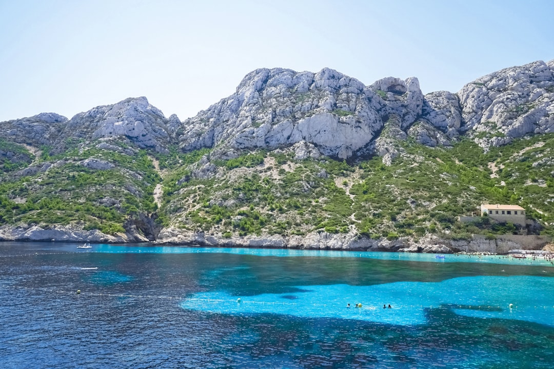 green and gray mountain beside blue sea during daytime