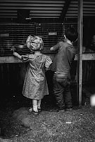 A field trip scene with kids observing farm animals.