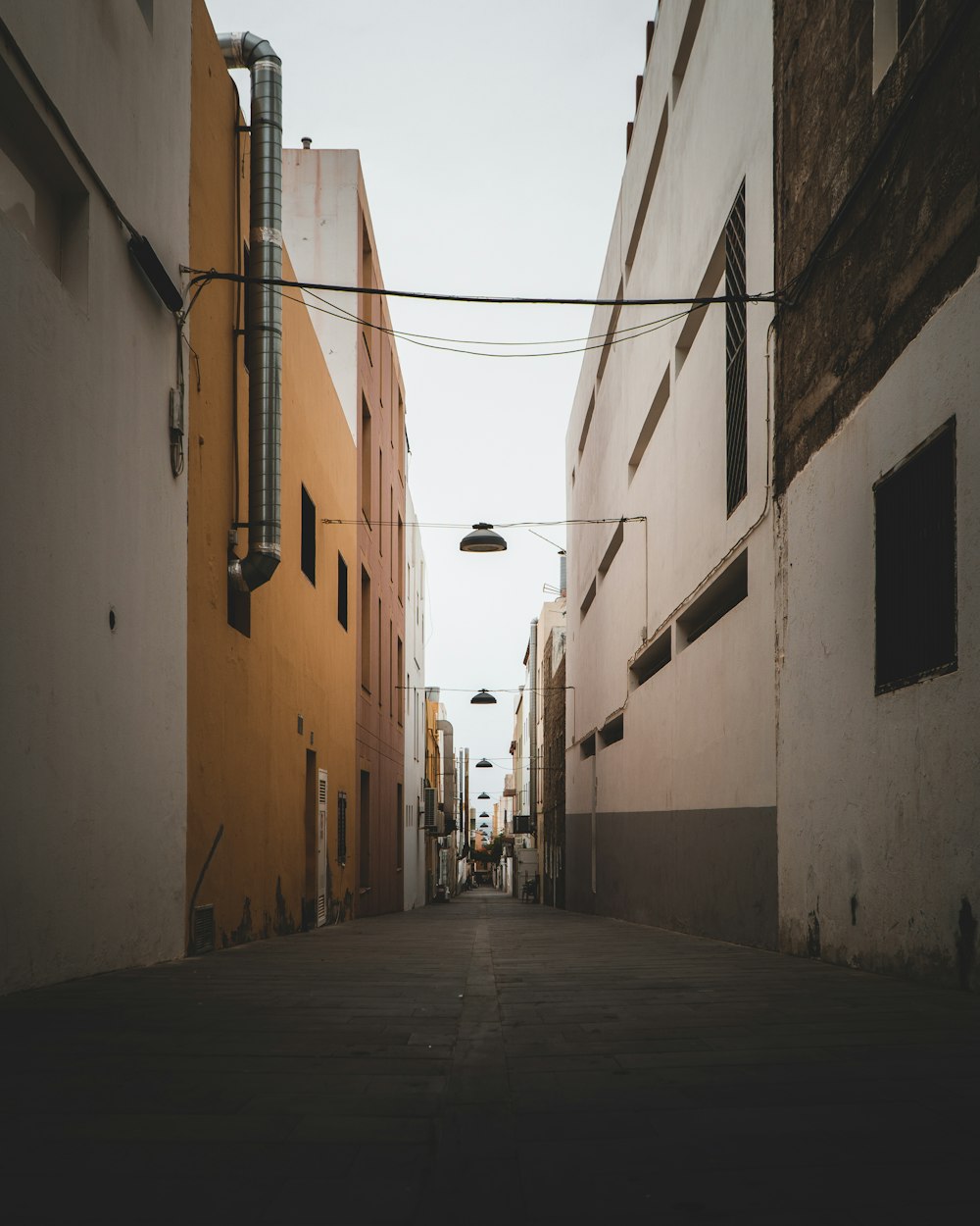 empty hallway between concrete buildings during daytime