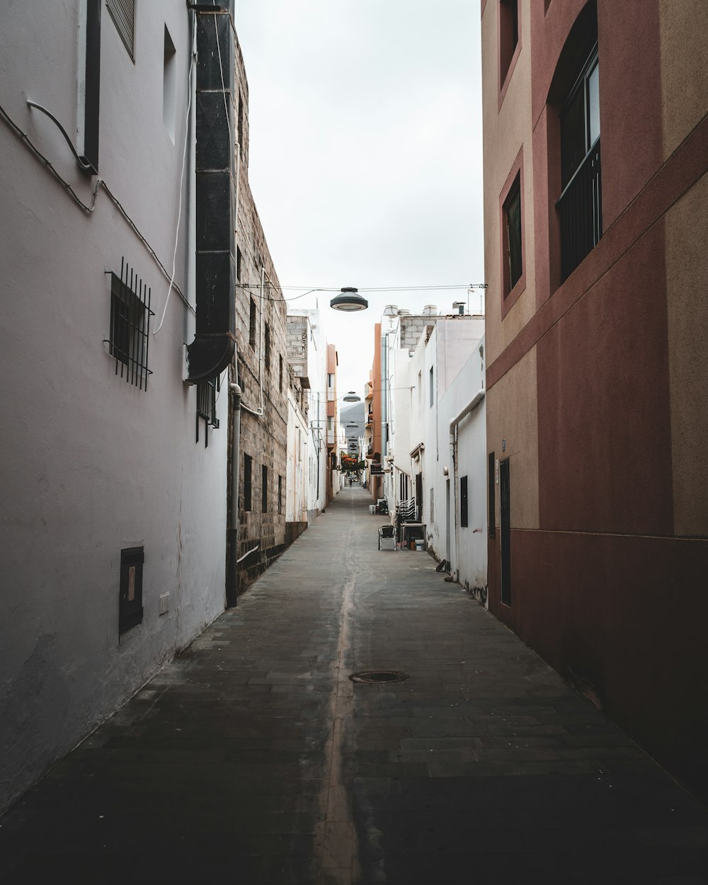 empty street between concrete buildings during daytime