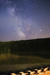 Guests relaxing on a wooden deck overlooking the quiet ranch under a starry night sky.