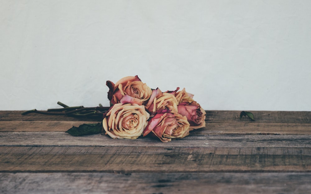 茶色の木製のテーブルにピンクのバラ