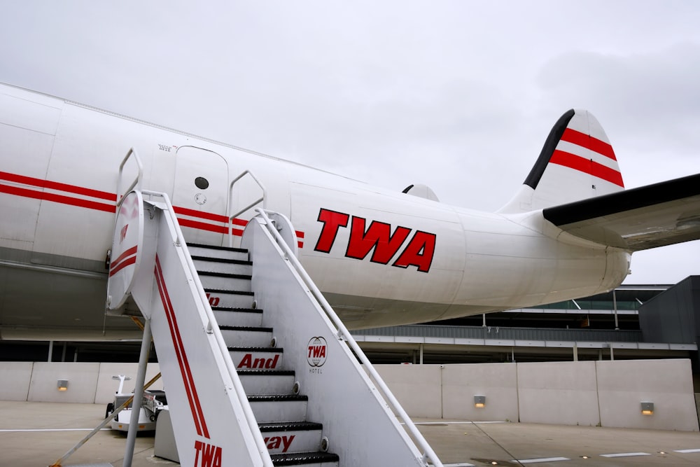 white and red airplane under white sky during daytime