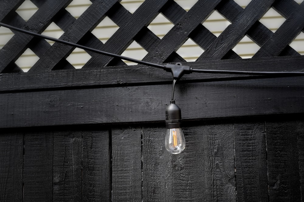 silver pendant lamp on black wooden wall