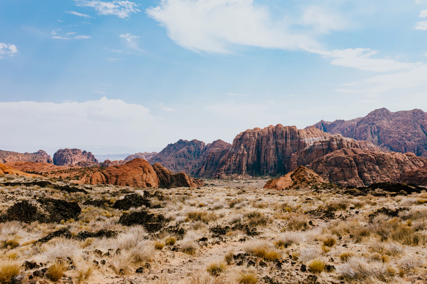 Red sandstone cliffs and desert scrub under a clear sky in southwestern Utah