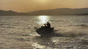 A jet ski gliding past the shimmering coastline of Marina Smir at dusk.