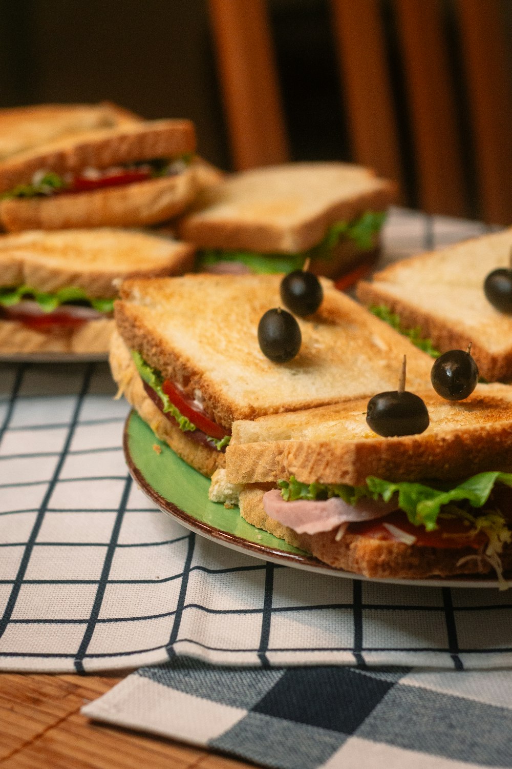 brown bread with green vegetable on white and black checkered textile