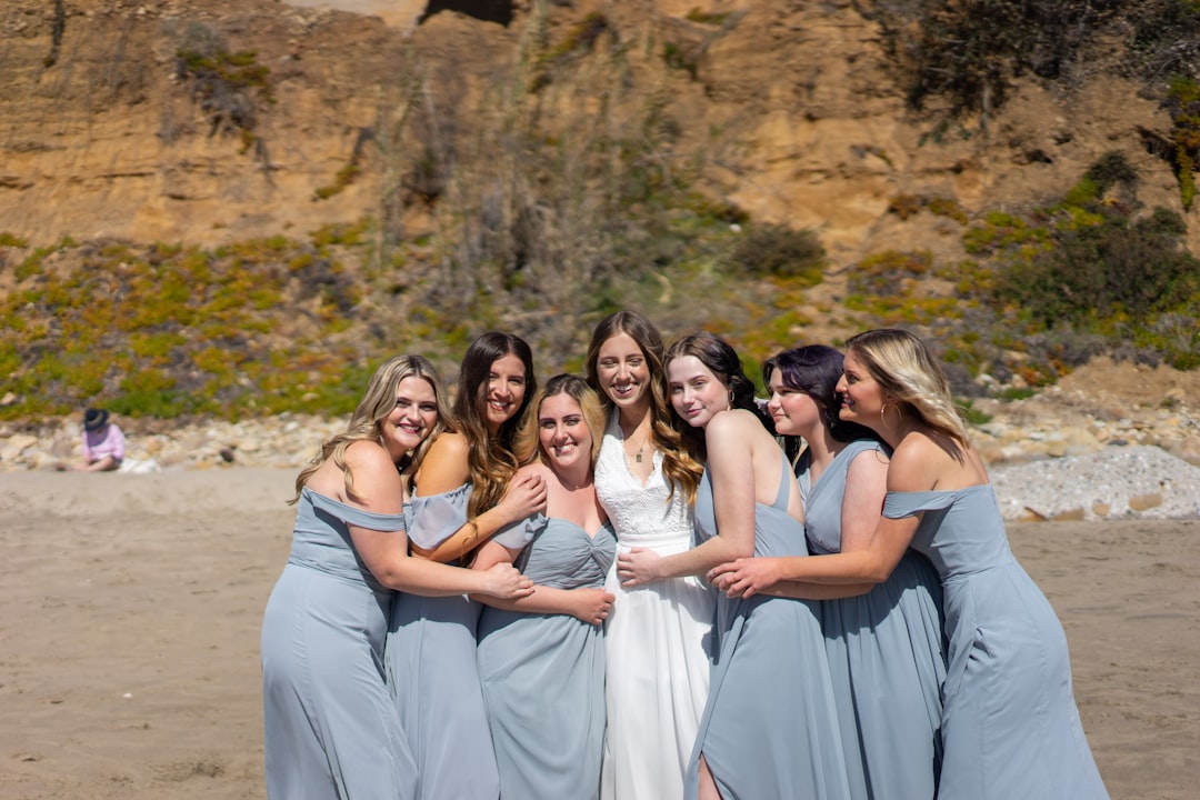 six women in white dresses posing for photo