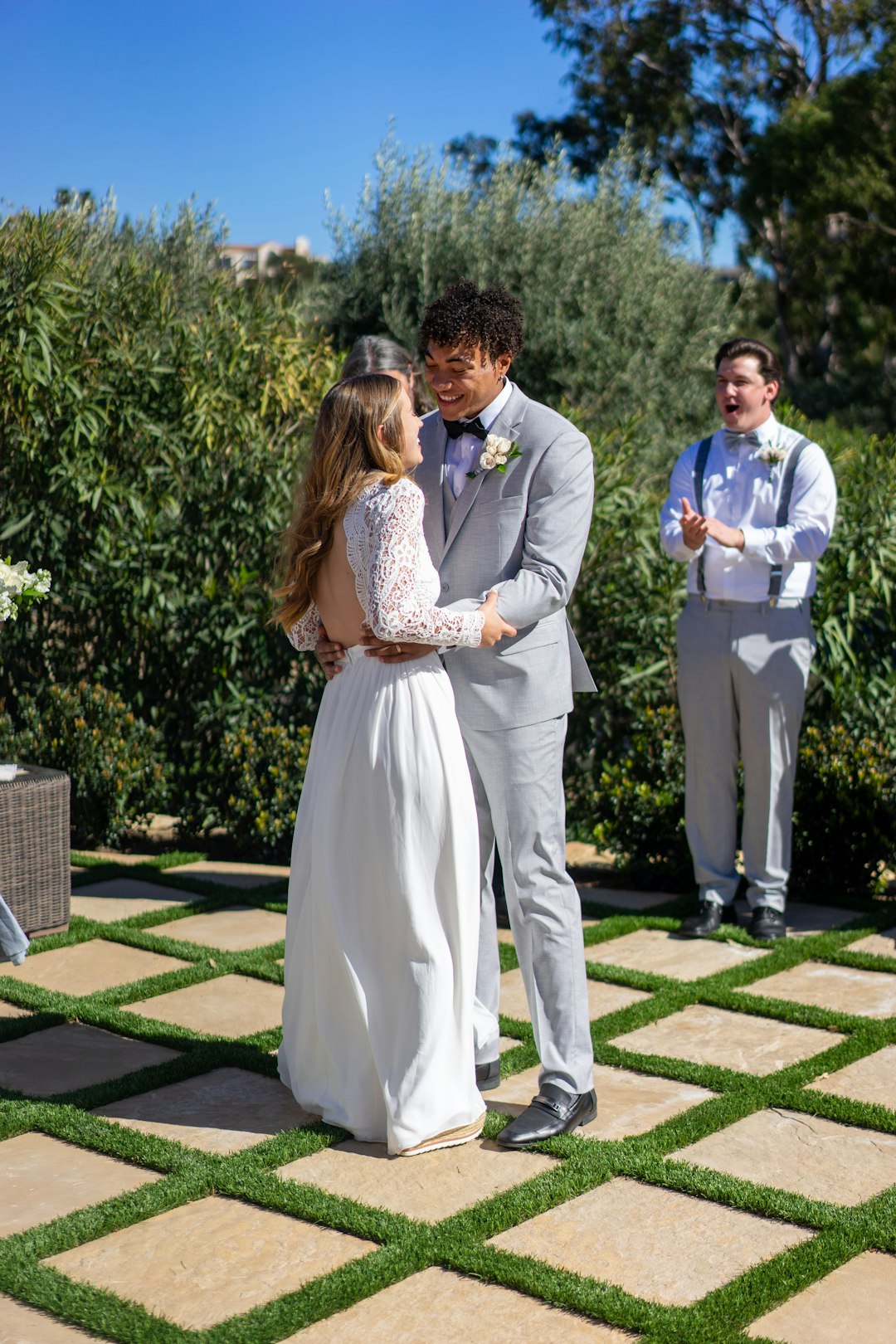 man in blue suit jacket and woman in white dress walking on green grass field during