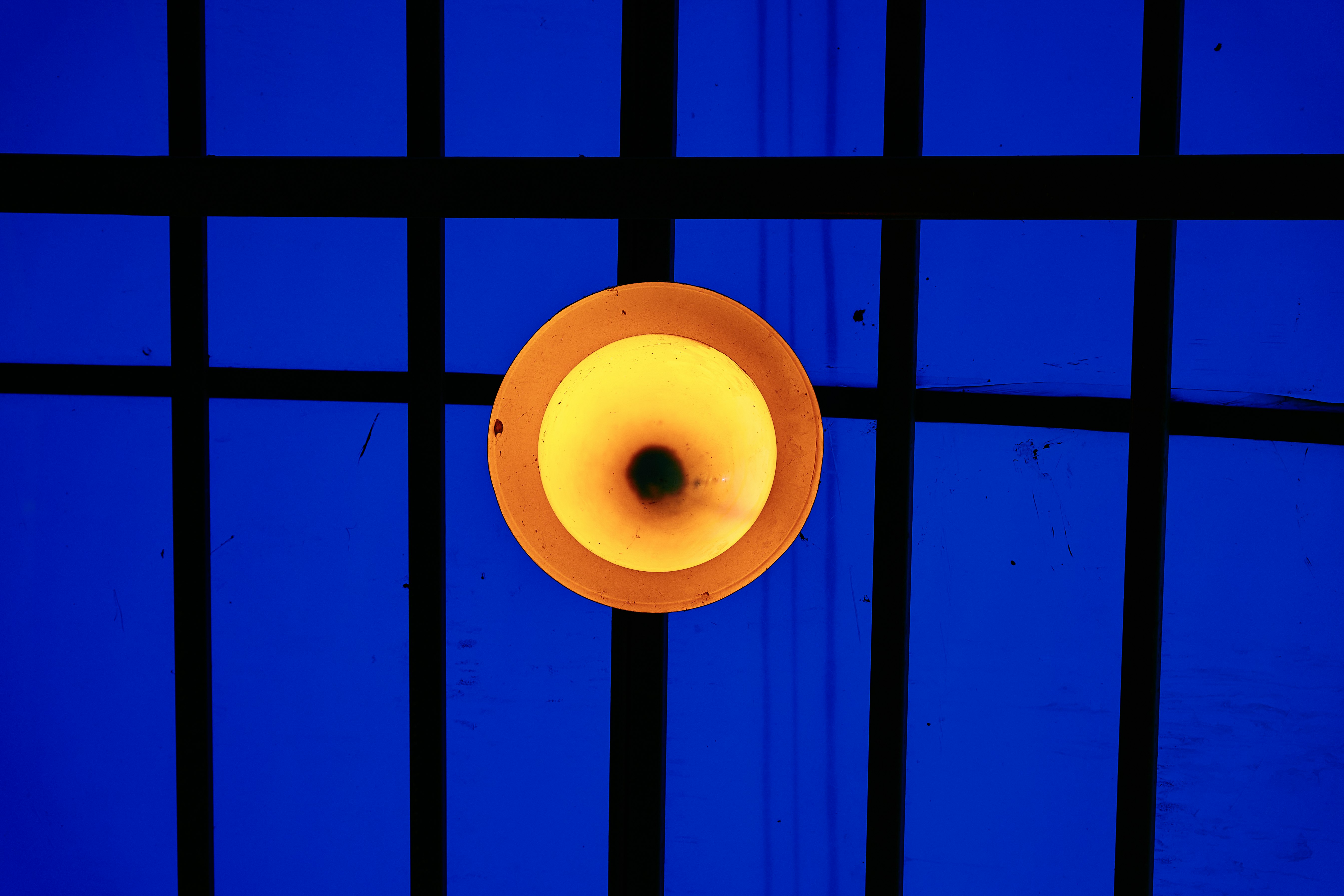 white round light bulb on blue metal frame