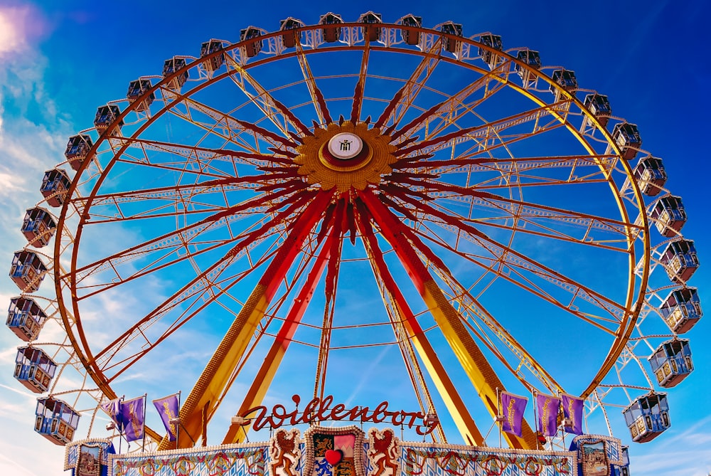 personnes roulant sur un carrousel jaune et rouge pendant la journée