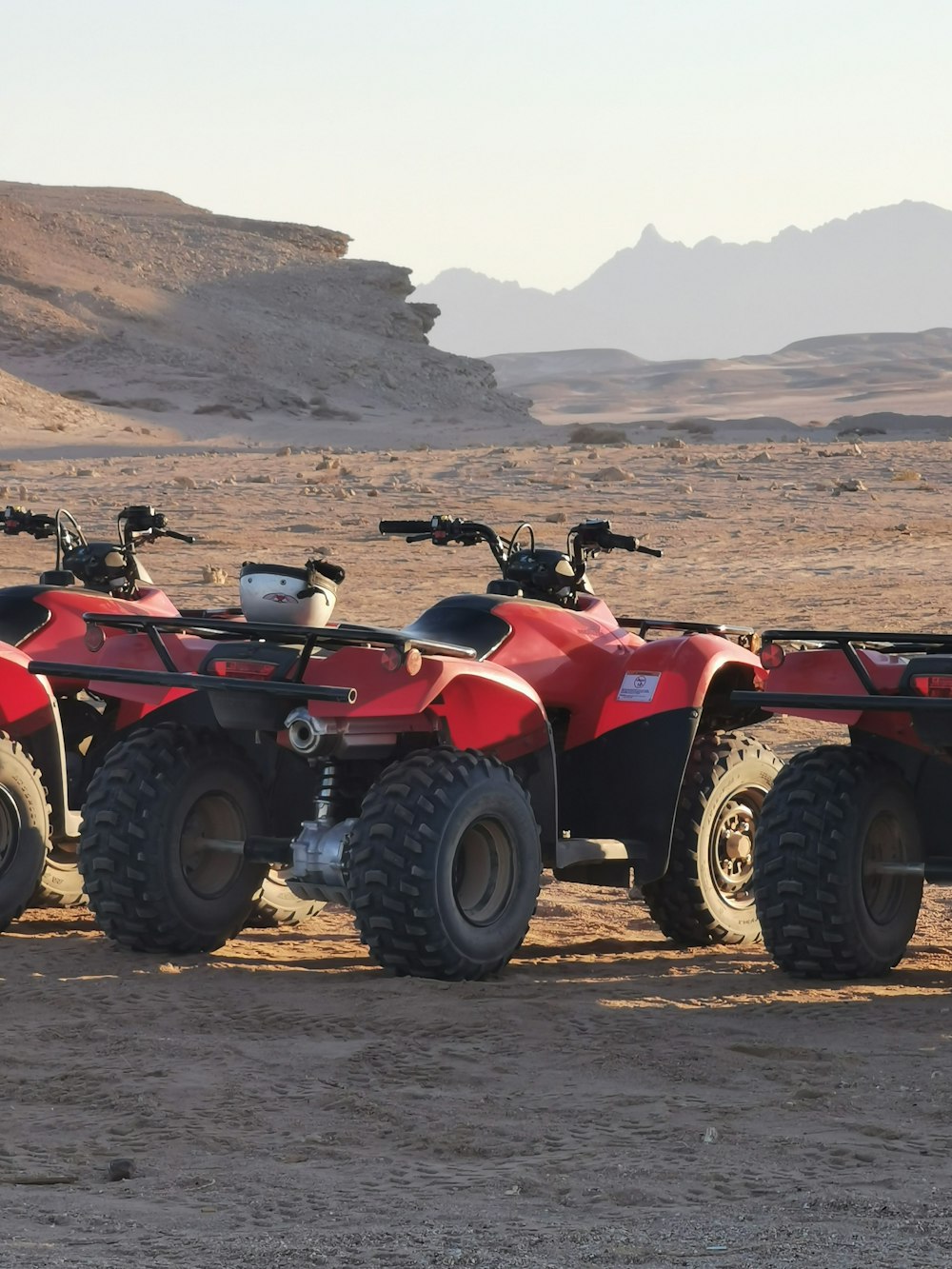 Rotes und schwarzes ATV auf braunem Sand