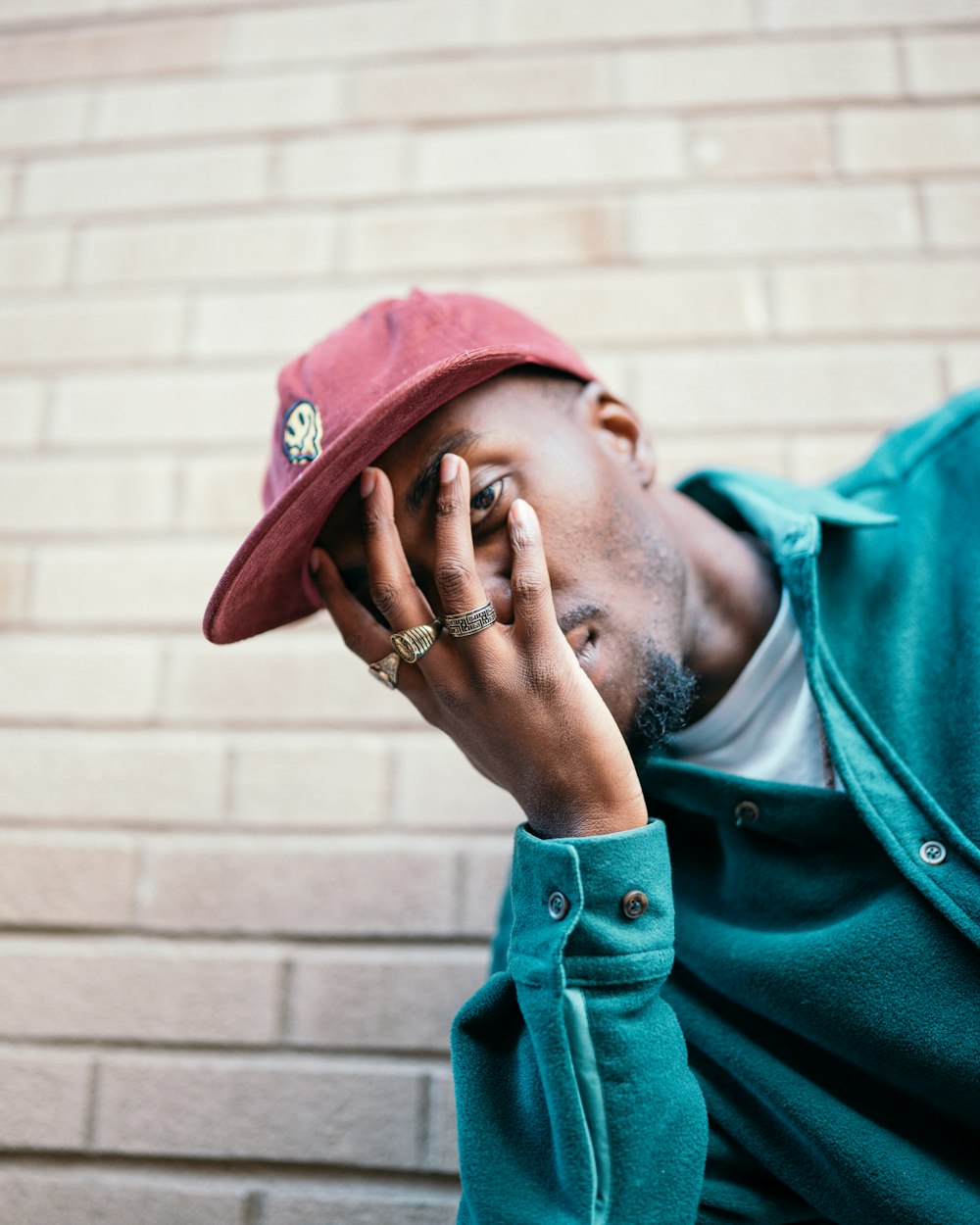 man in green button up shirt wearing red hat