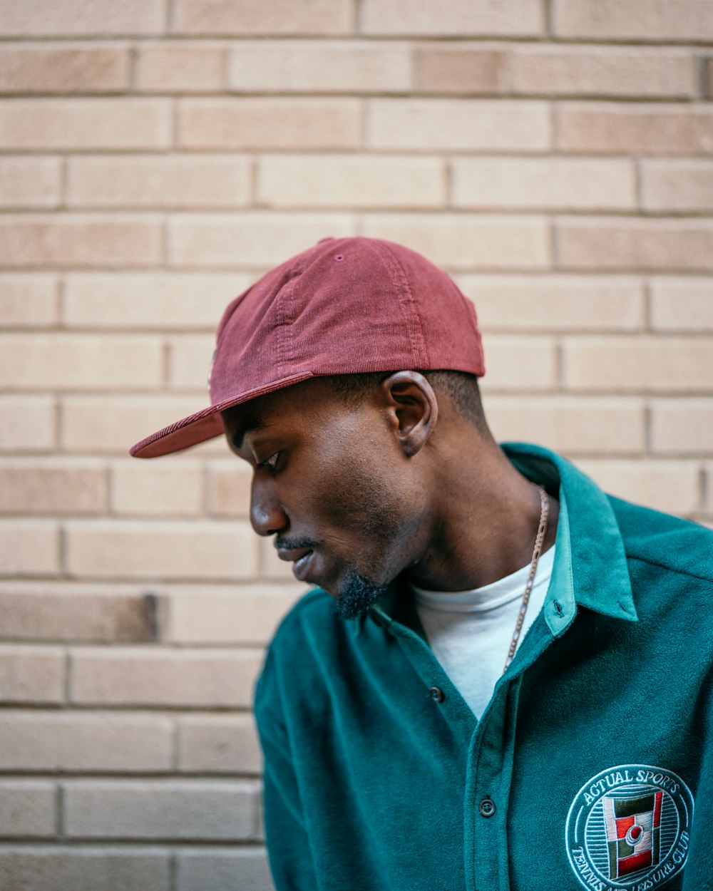 man in green button up shirt wearing red cap