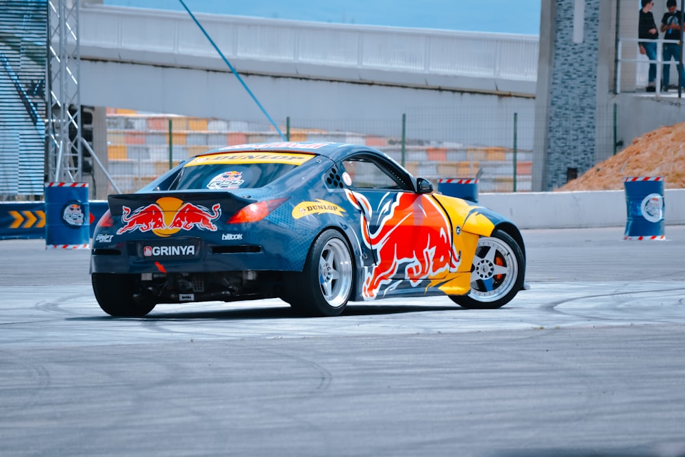 blue and orange porsche 911 parked on gray pavement