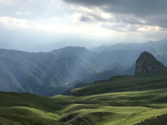 green grass field and mountains under white clouds and blue sky during daytime in Tavush Province Armenia