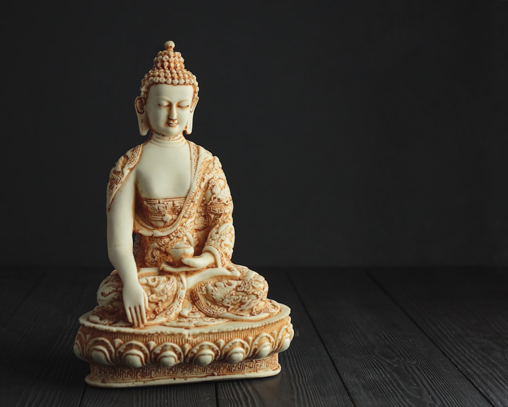 Figura de Buda de oro sobre mesa de madera marrón