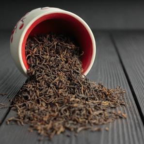 Close-up of loose-leaf black tea gently resting in a minimalist ceramic bowl.