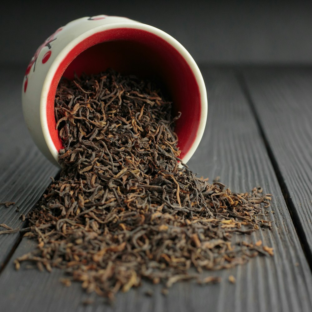 brown dried leaves in red and white ceramic mug