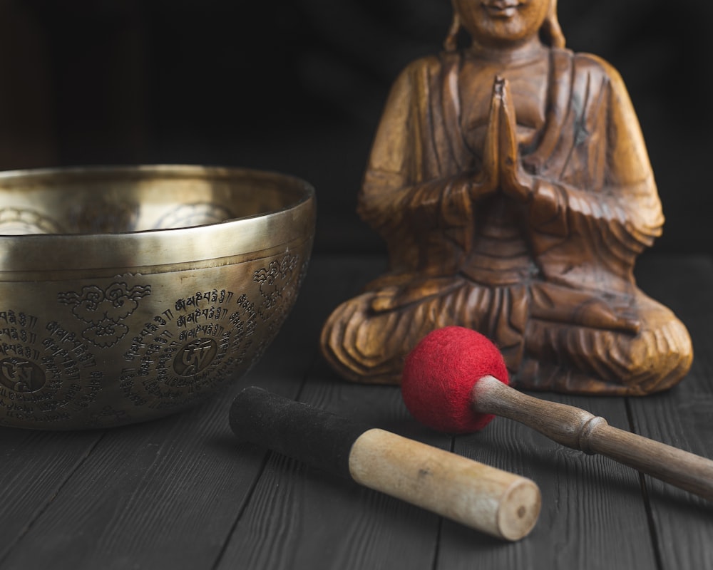 brass buddha figurine beside red and white stick