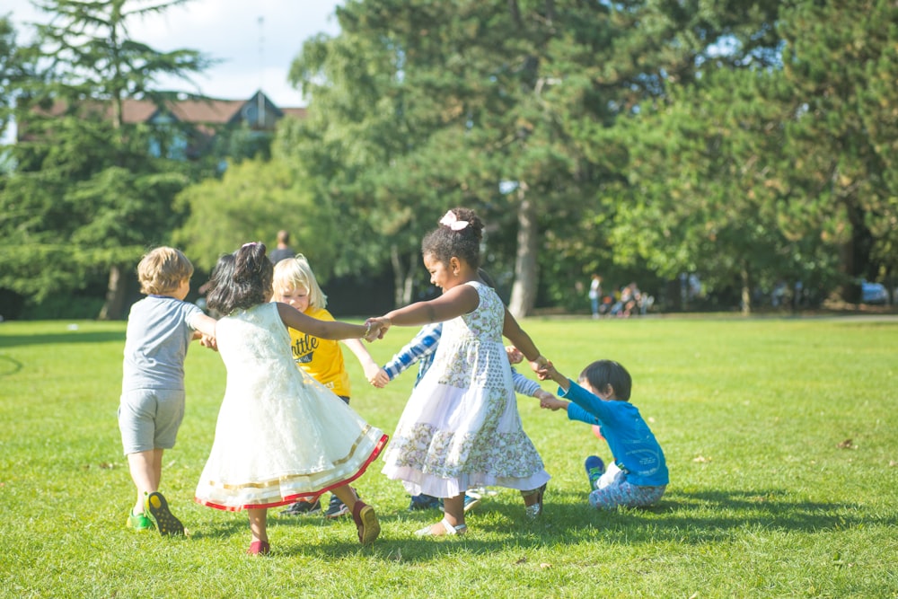 낮 동안 푸른 잔디밭에서 하얀 드레스를 입은 소녀와 춤을 추는 하얀 드레스를 입은 여자