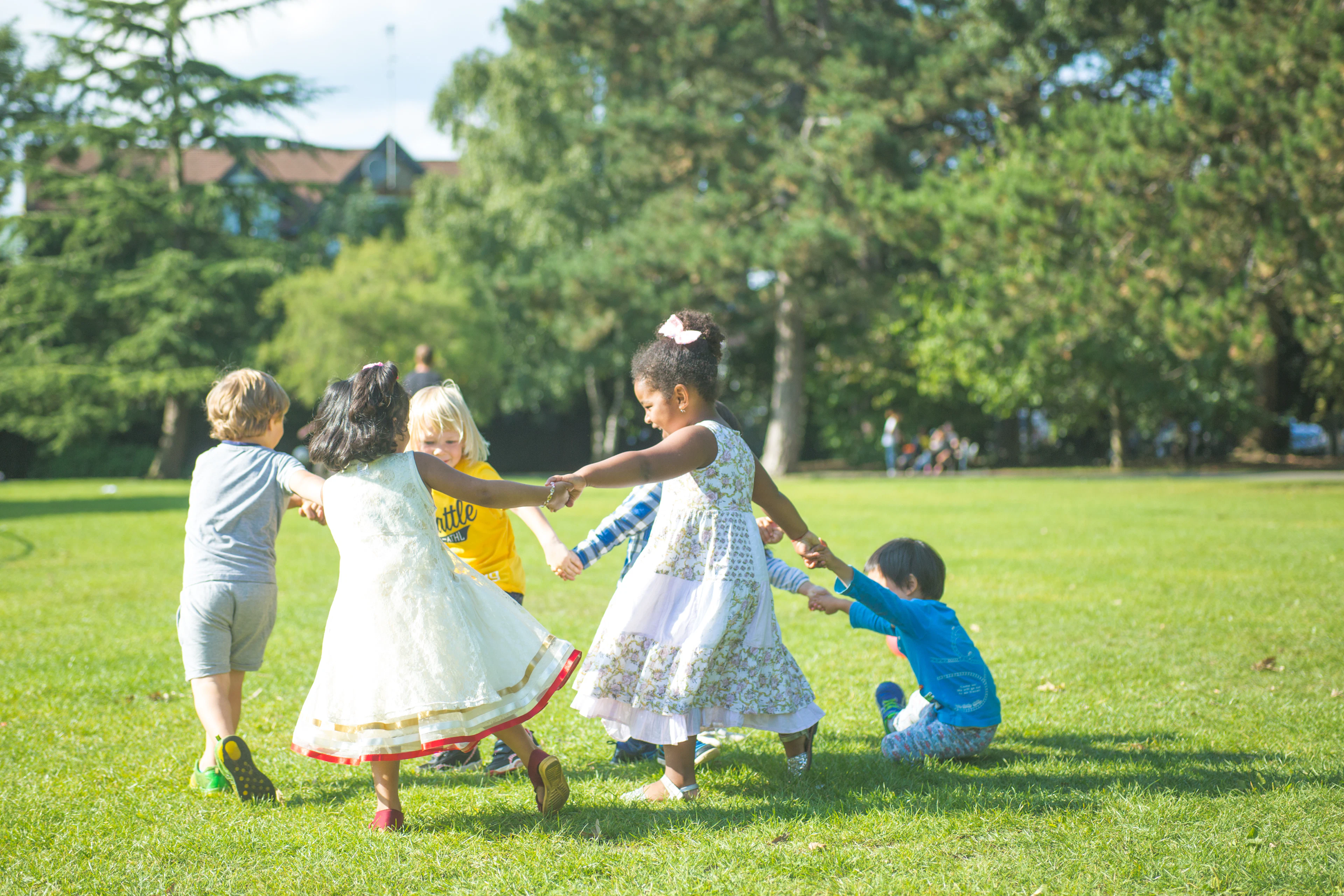 Niños tomados de la mano jugando en círculo