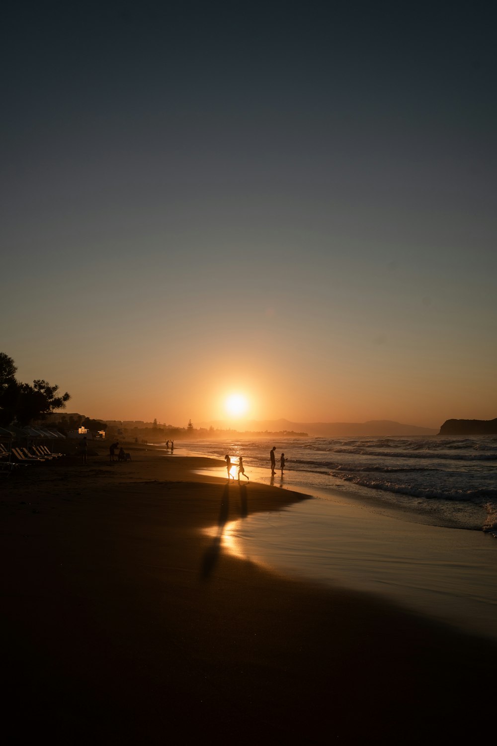 silhouette of people walking on beach during sunset