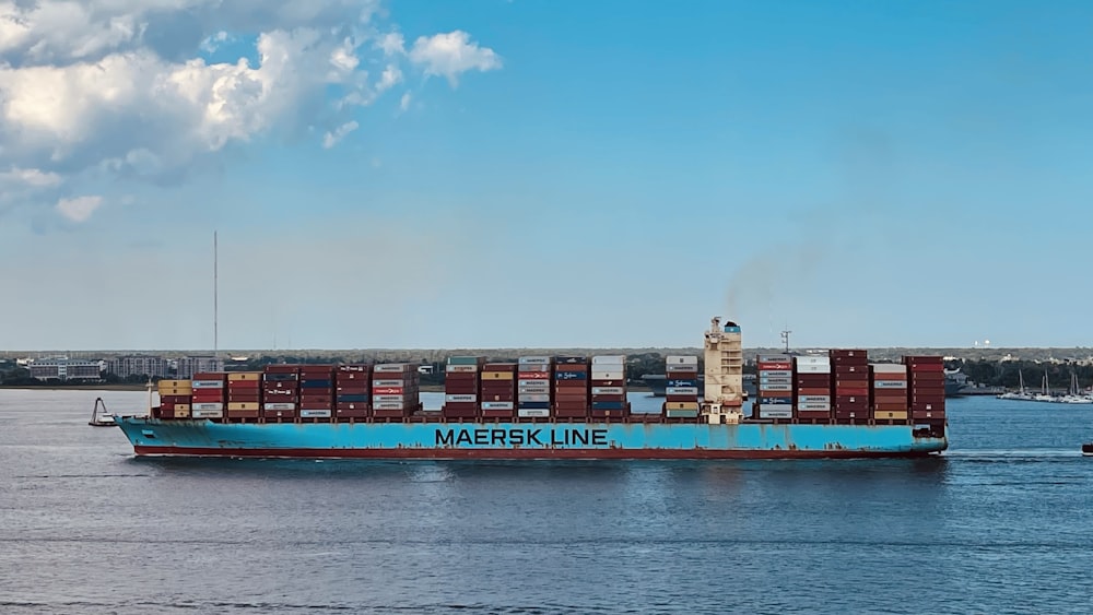 red and black cargo ship on sea under blue sky during daytime