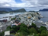 A panoramic view of a coastal city with green parks and modern buildings.