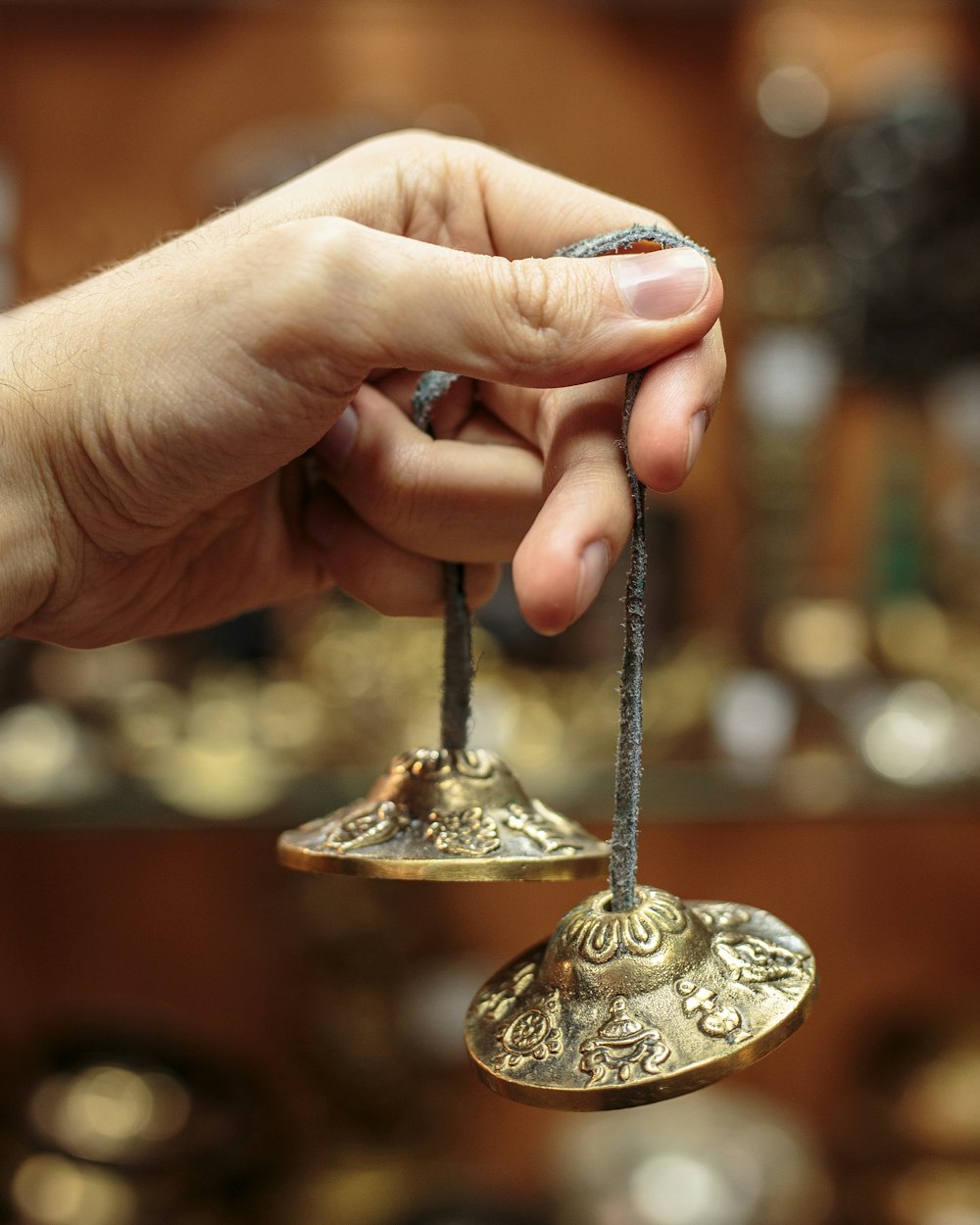 person holding gold steel round ornament