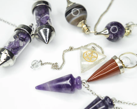 Close-up of natural stones and pendulums used in energy work.