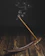 Close-up of traditional Moroccan sarghine incense sticks glowing softly in a rustic clay holder.