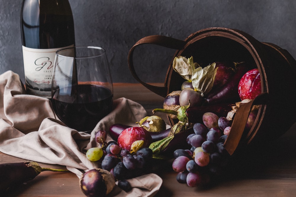 wine glass beside grapes and wine glass on table