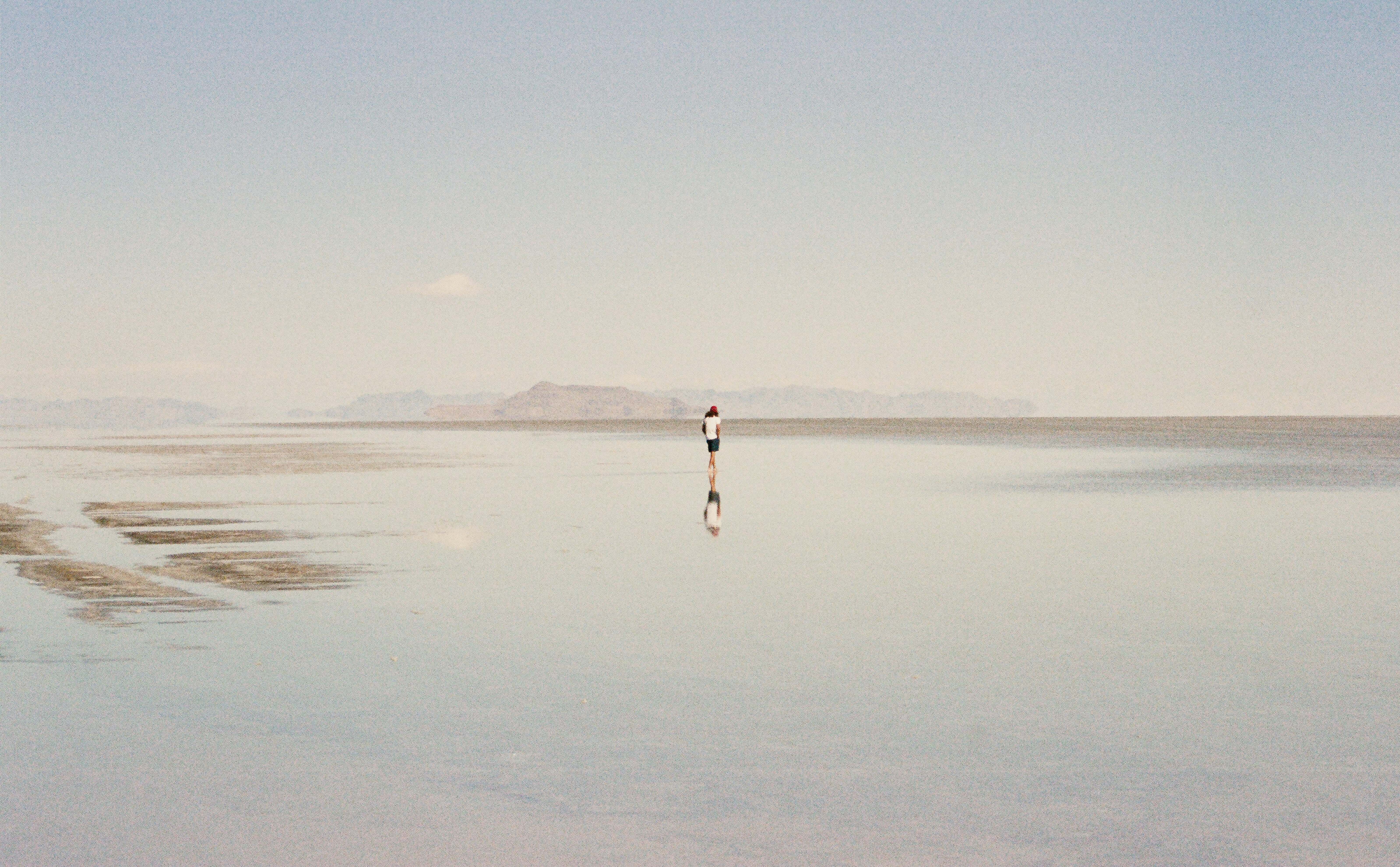 person in white shirt walking on beach during daytime
