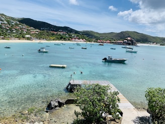 A vibrant turquoise bay with traditional Malagasy pirogues under a bright sky.
