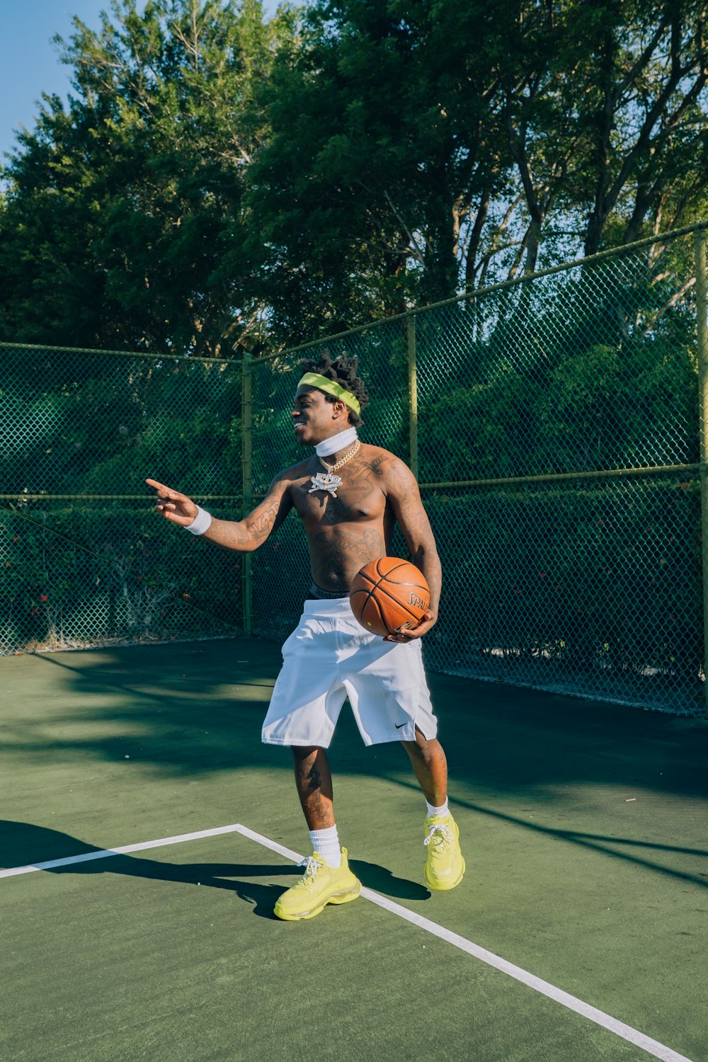 man in white shorts and white nike basketball shoes holding basketball